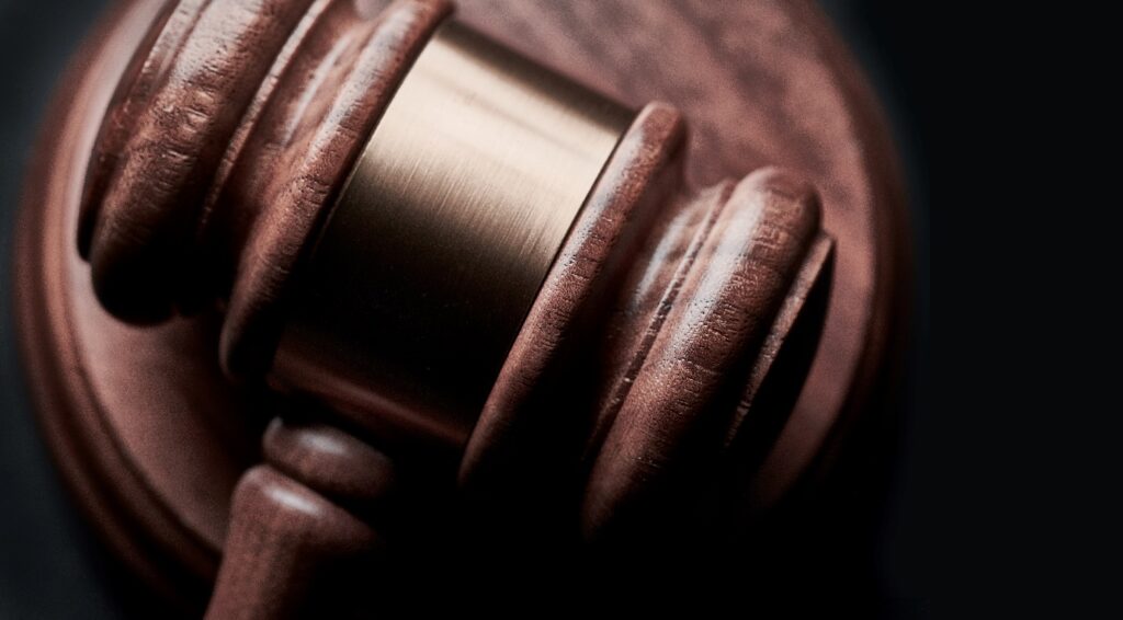 A brown gavel lying on a sound block