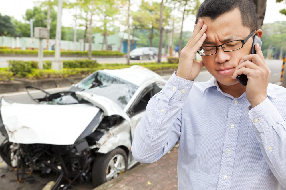A person upset and on the phone following a car accident.