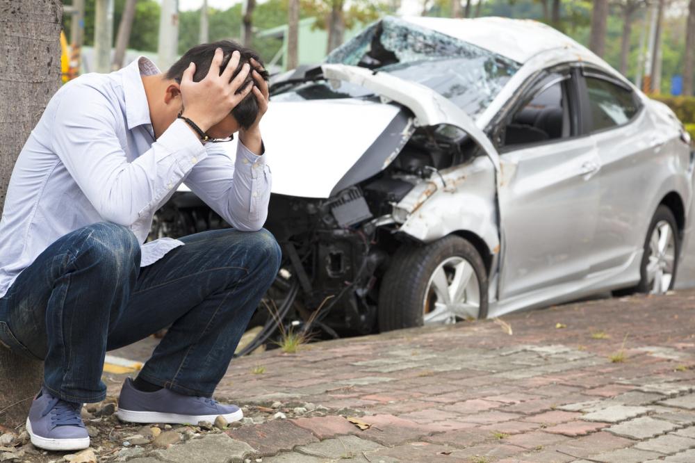 An upset driver at the scene of a car accident.