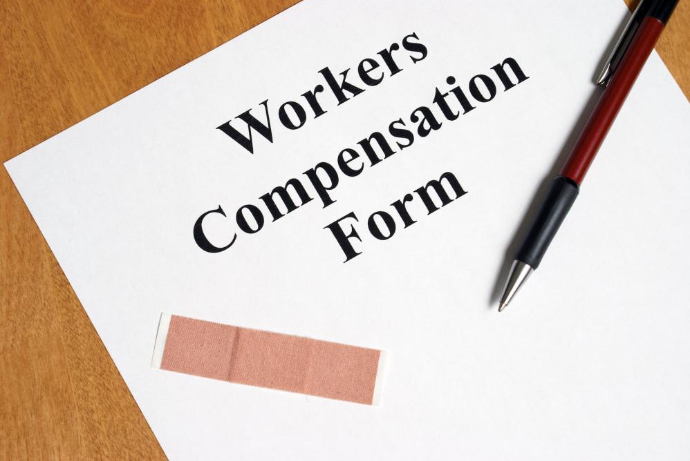 An image depicting a workers’ compensation form, pen, and a band-aid.