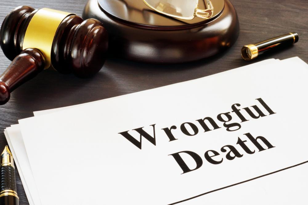 A wrongful death form lying near a gavel and pen.